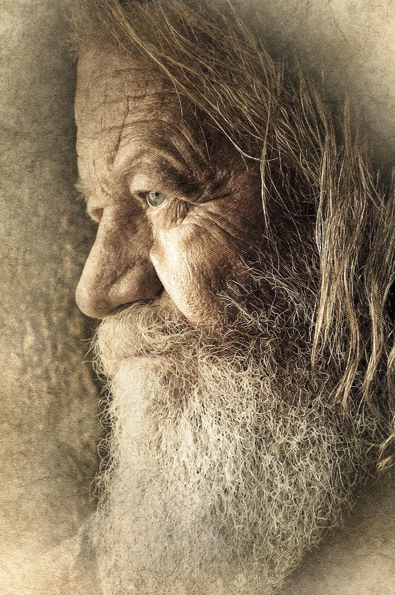 Portrait photographique vintage sépia d'un homme âgé aux longs cheveux gris, à la barbe blanche, aux rides profondes et aux yeux bleus.