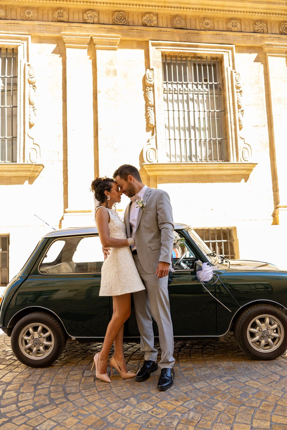 Couple de mariés enlacé devant une voiture ancienne à Aix-en-Provence