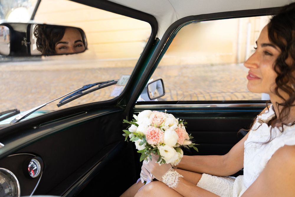Mariée assise dans une voiture ancienne avec son bouquet à Aix-en-Provence
