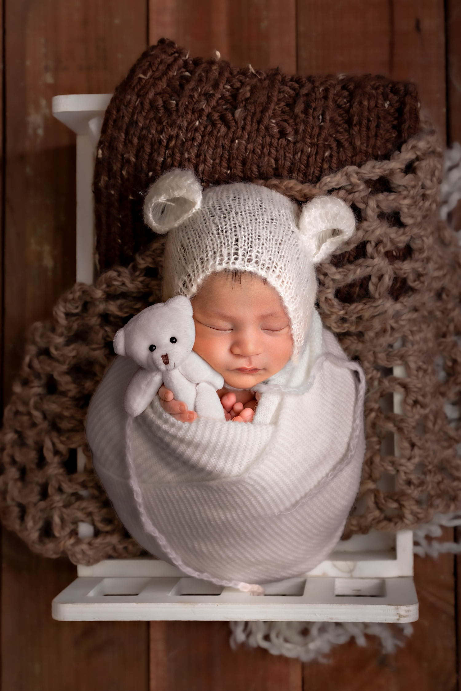 In-home newborn photography in Fresno California by Colibri Captures sleeping baby wrapped in white swaddle.