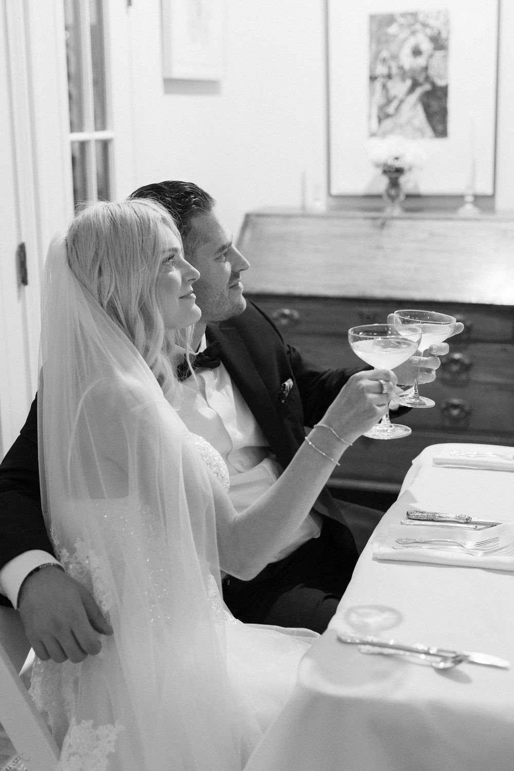 Bride and groom toast in documentary black and white photo