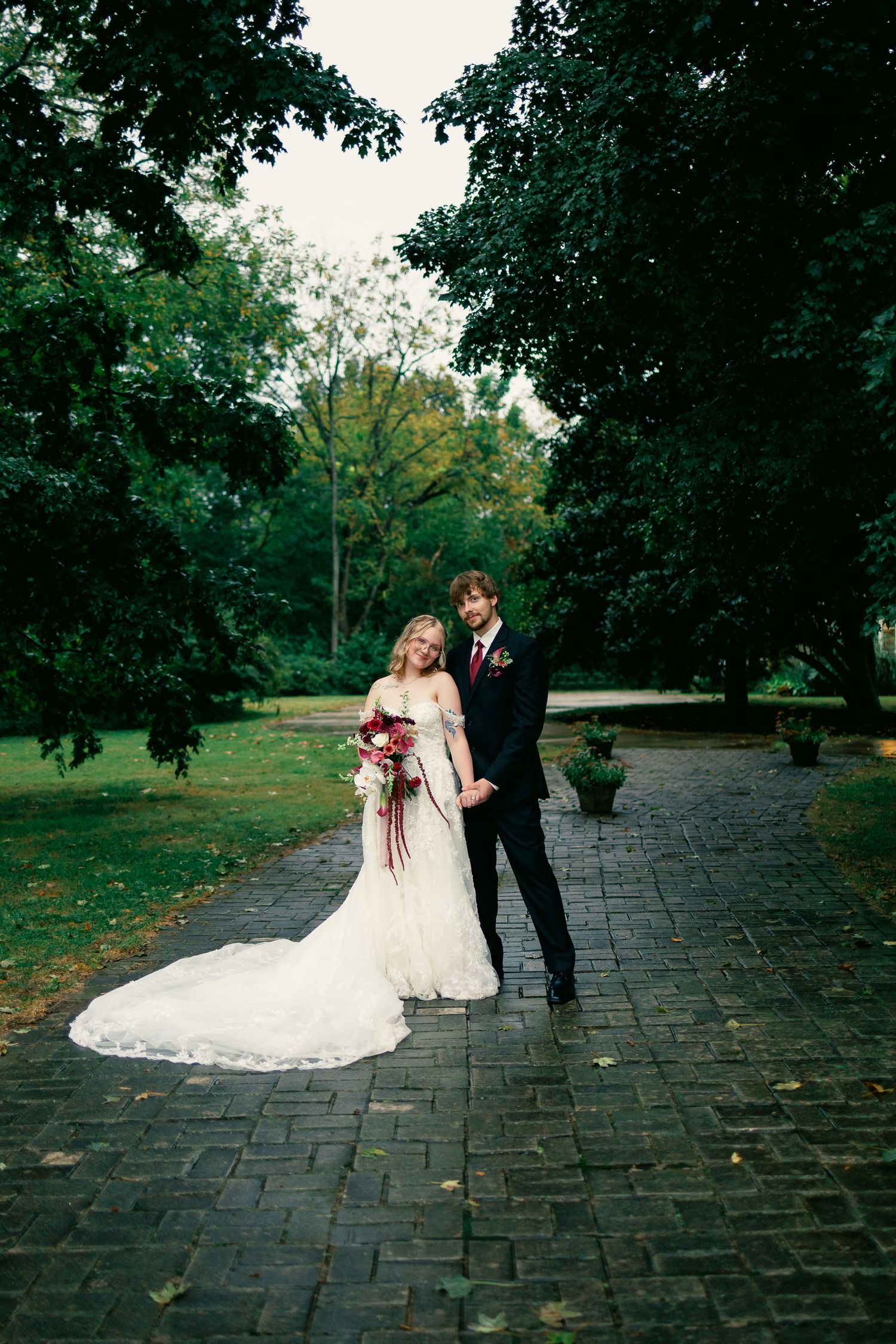 Black and white photo of bride and groom embracing, showcasing wedding dress, veil, and groom suit at elegant ceremony.