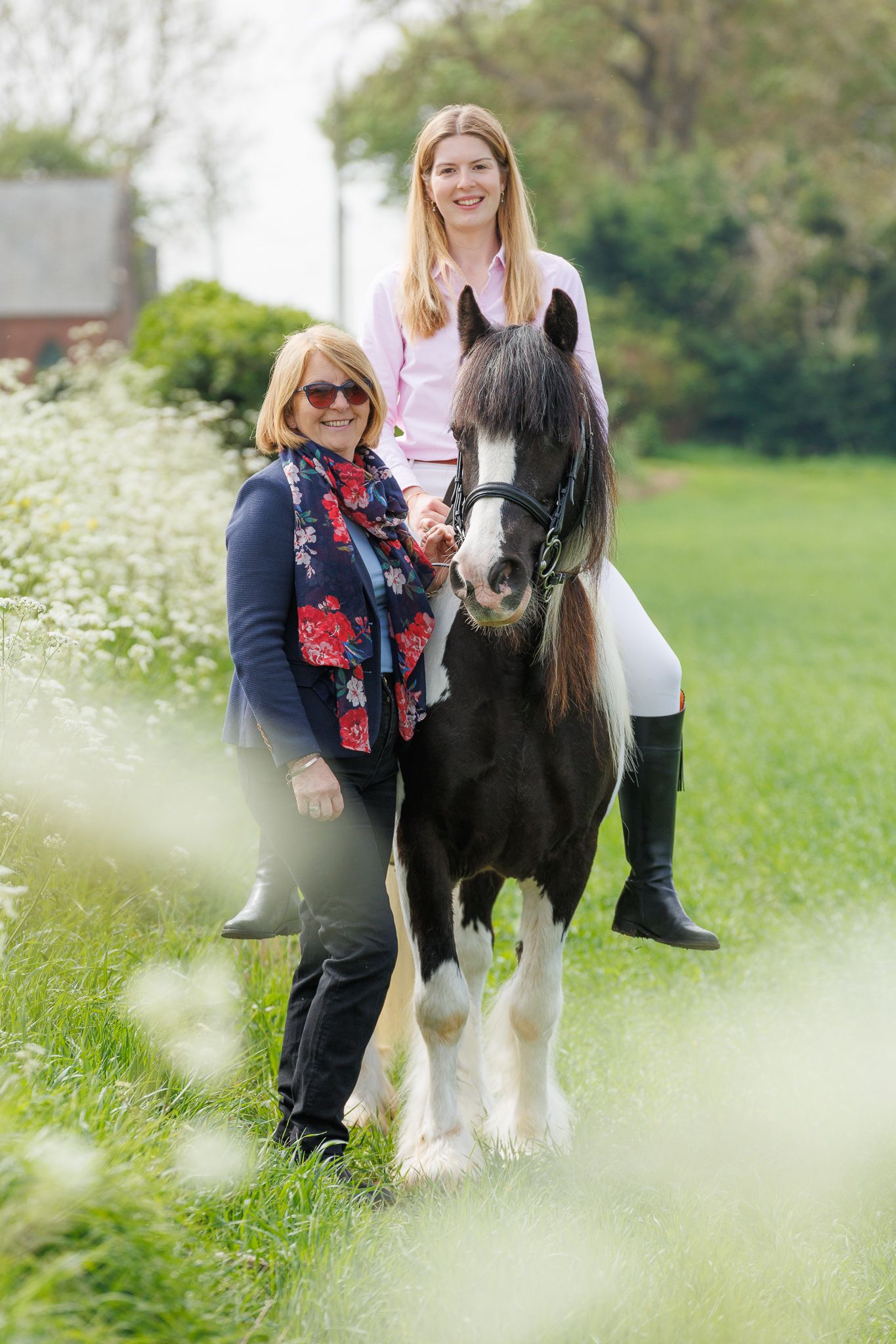 A series of photos showing a person in a white polka dot shirt with a black horse in a golden autumn field.
