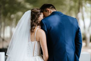 A tender embrace between newlyweds during their outdoor wedding ceremony.