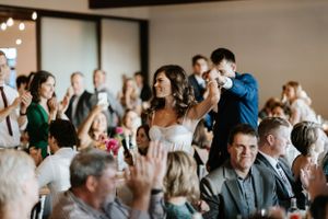 Wedding reception crowd cheers as couple celebrates their special moment.