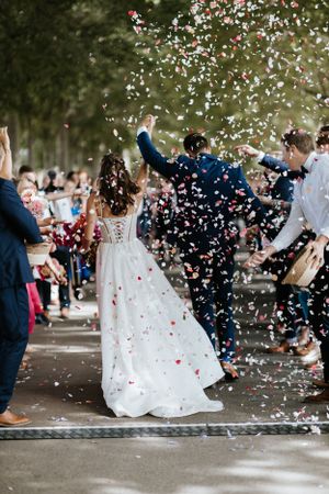 Confetti fills the air as newlyweds celebrate during their outdoor wedding ceremony.