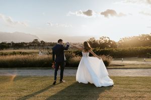 Newlyweds watch sunset together on their wedding day with scenic mountain backdrop.