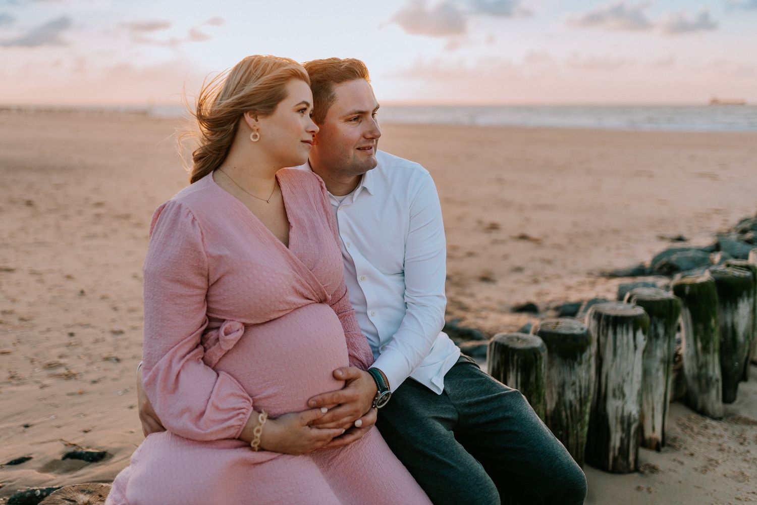 Intieme zwangerschapsshoot vrouw met partner met make-up en styling in Terneuzen, Zeeland, Oost-Vlaanderen. Op het strand met golden hour.