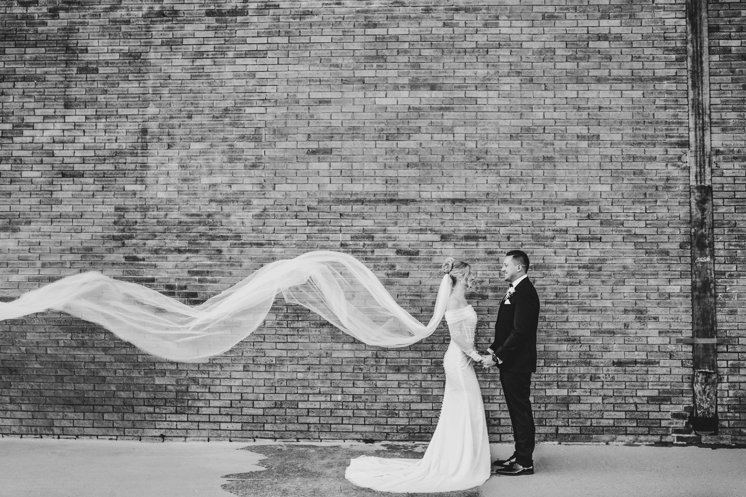 husband and wife hold hands outside of their wedding venue in deep ellum
