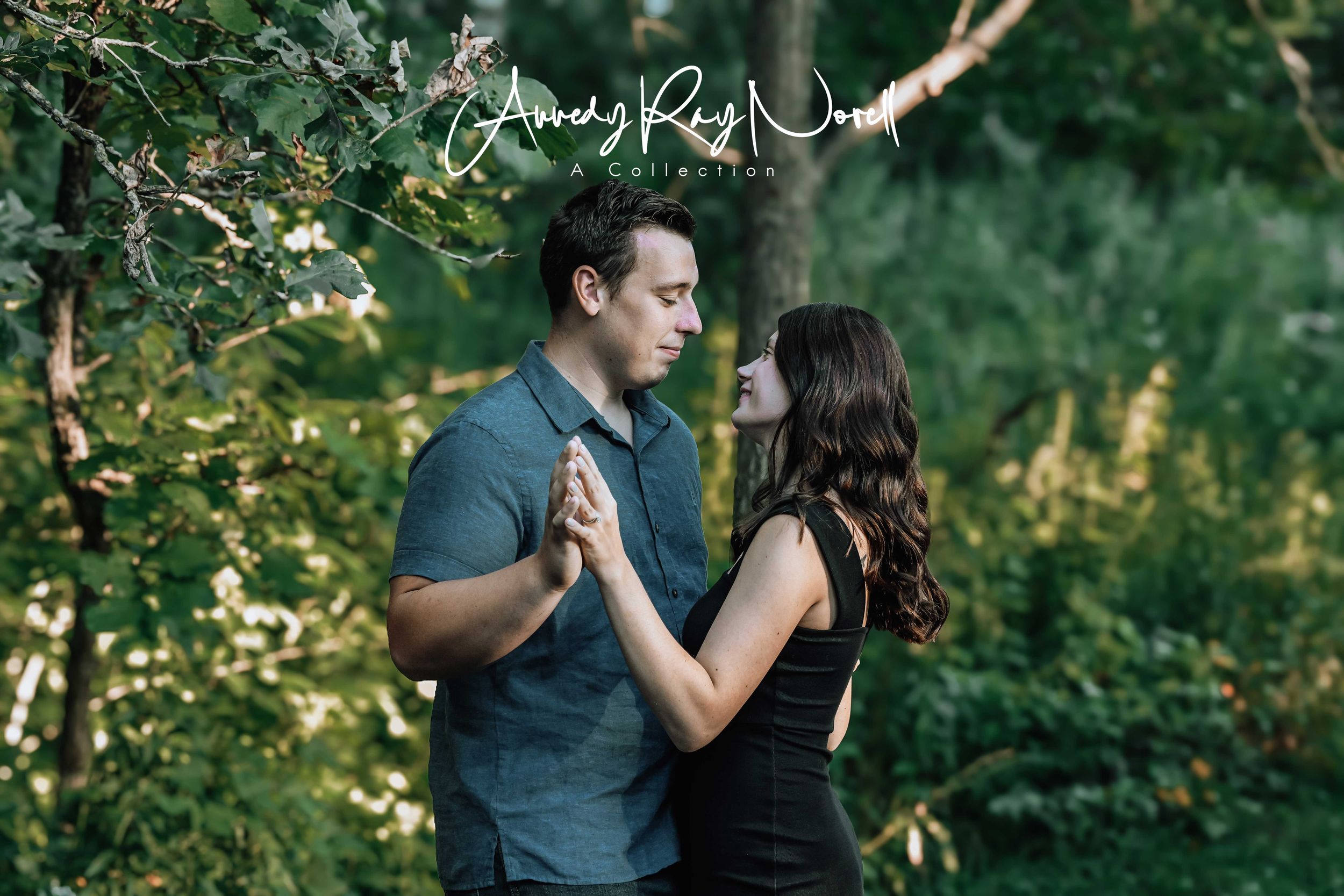 Couple holding hands and gazing at each other in a lush green forest during golden hour.