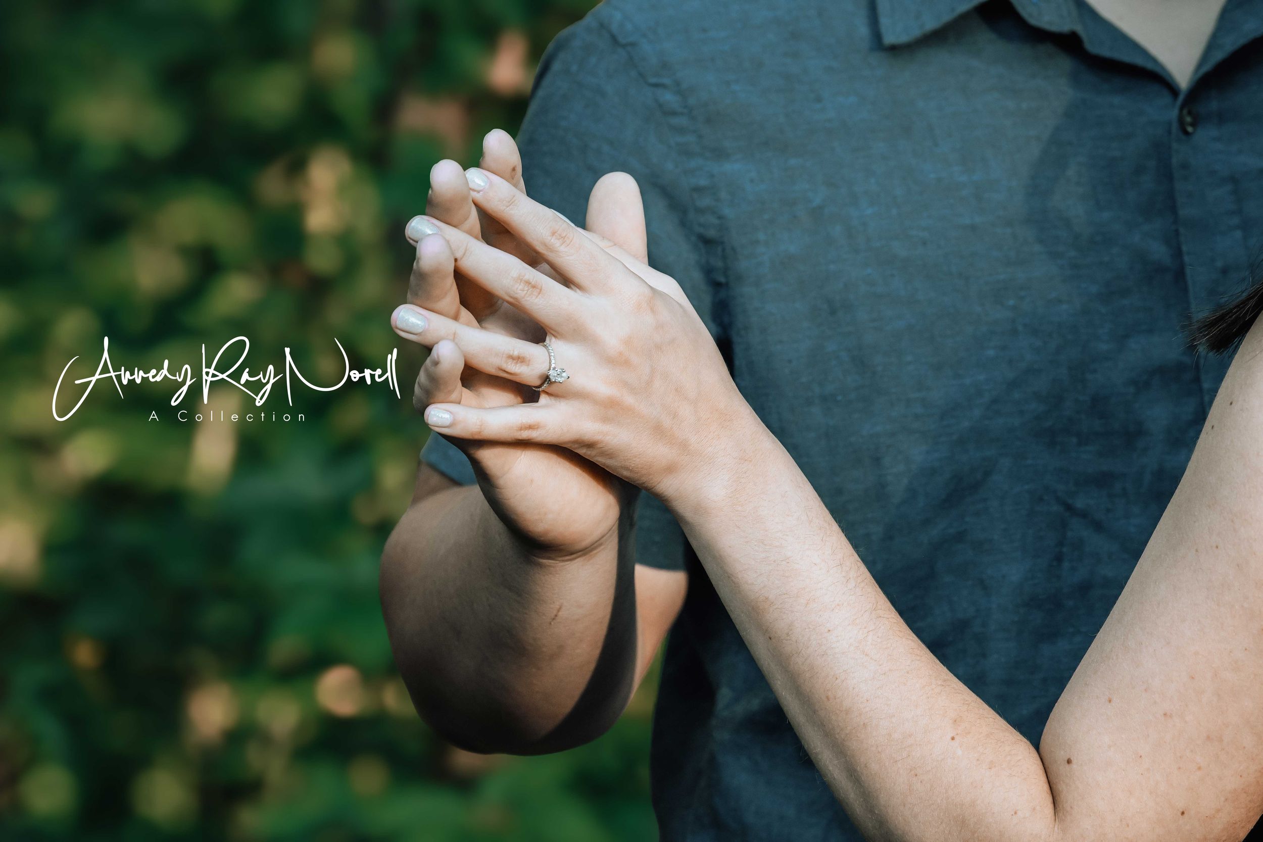 Close-up of couple holding hands showing engagement ring, photographed by Andy Ray Wood Photography.