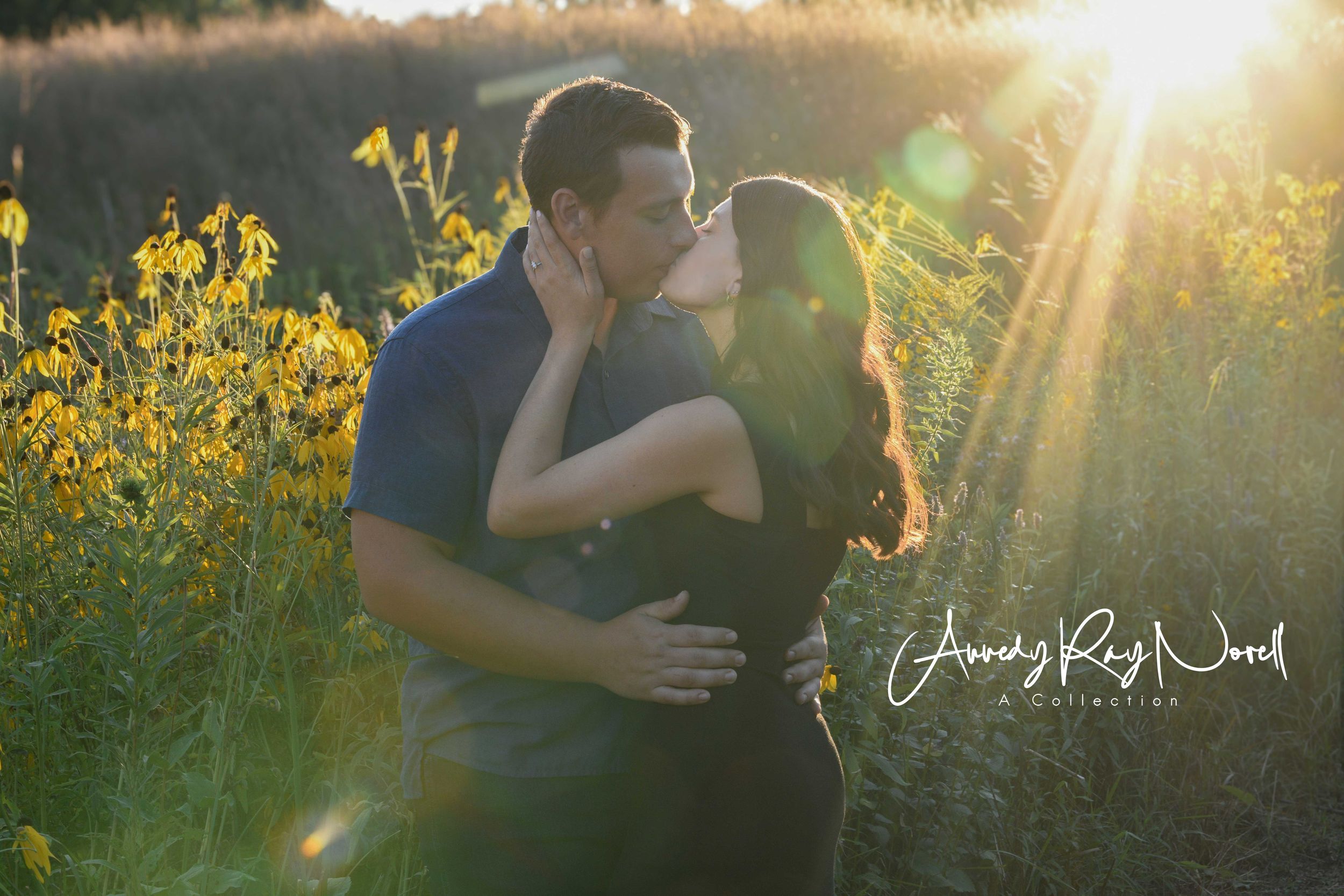 Couple sharing a romantic kiss in a sunlit field of yellow wildflowers at golden hour.