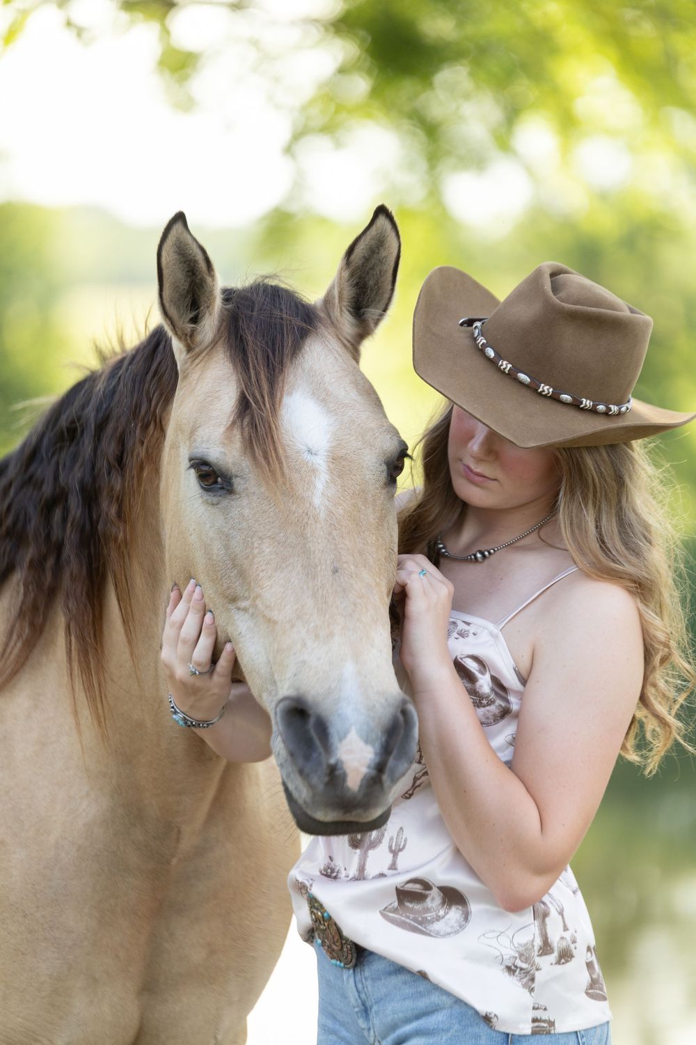 Close up cowgirl portrait with buckskin horse