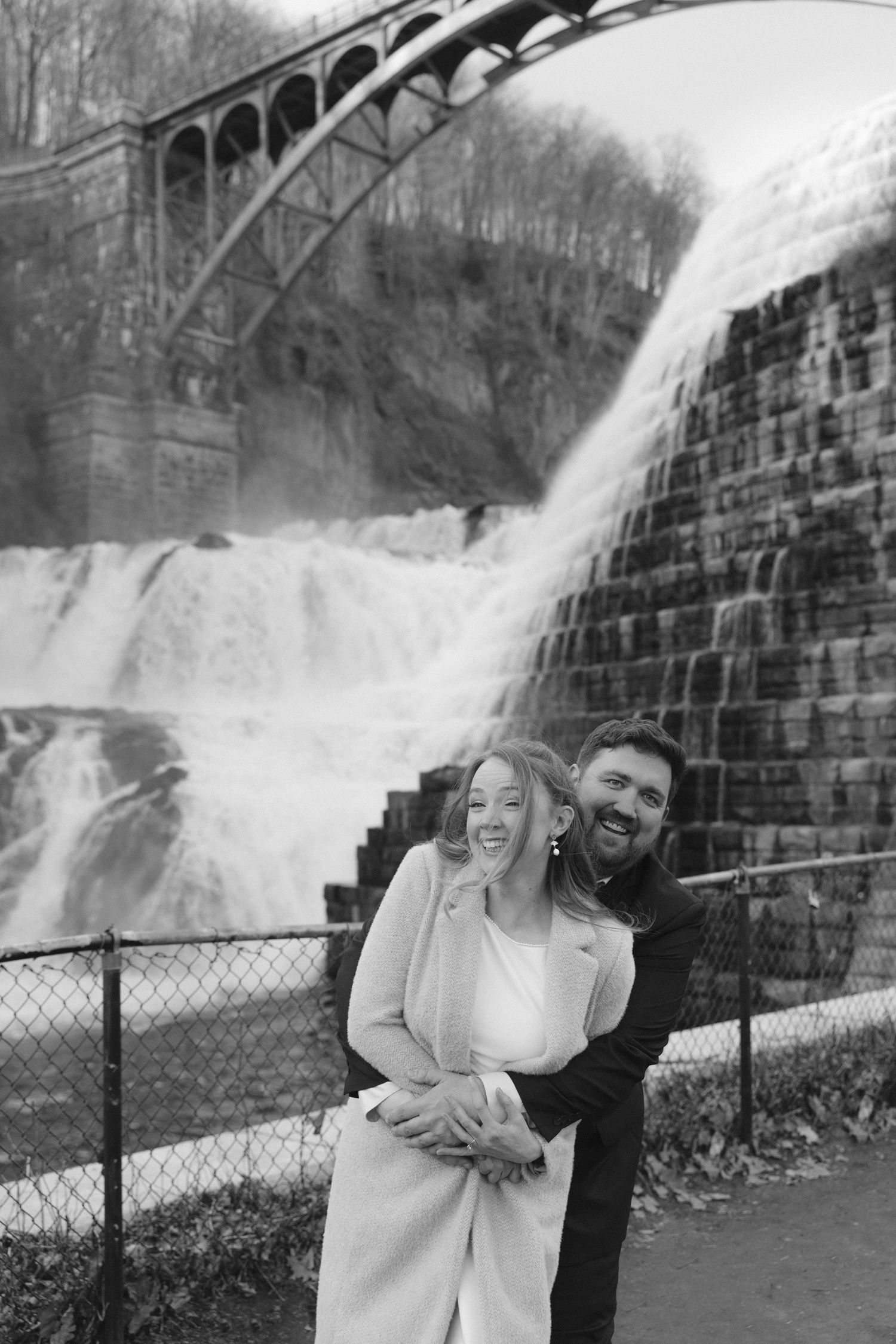 A joyful couple embraces and laughs outside the Beacon Movies theater on a snowy winter day.