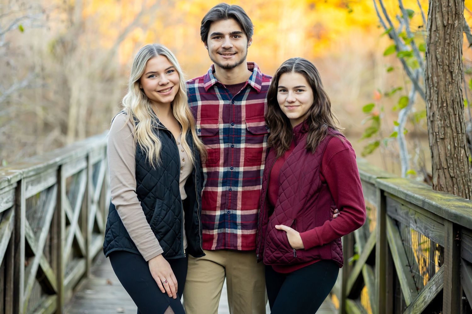 A family walking together and holding hands through tall grass in a sunny outdoor field. Fall styling guide. Richmond, Virginia family photo