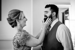 Mother of the groom grabs her son's beard as they get ready at the Equinox Resort in Vermont