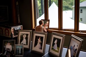 a bride gets ready surrounded by bride portraits from other family weddings