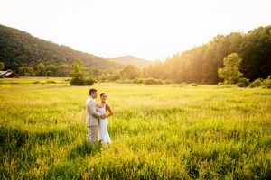 wedding couple in a grassy meadow in Vermont during golden hour at The Old Gray Barn