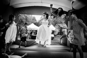 A bride jumps with wedding guests in an inflatable bouncy castle during the reception in Stowe, Vermont
