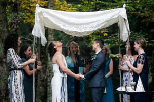 Wedding couple takes each other's hands underneath a Chuppah during the wedding ceremony