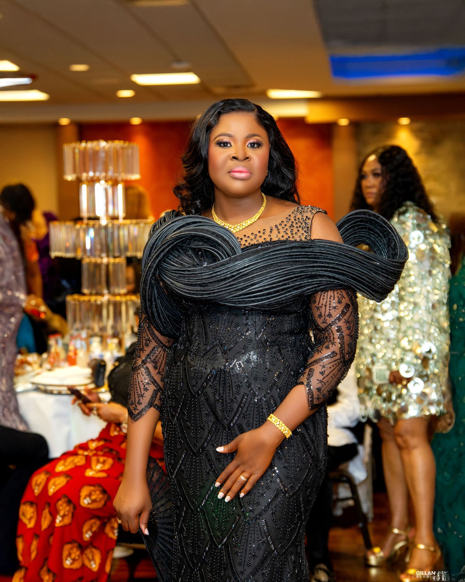 Glamorous evening gown with dramatic ruffle details and lace sleeves at formal event.