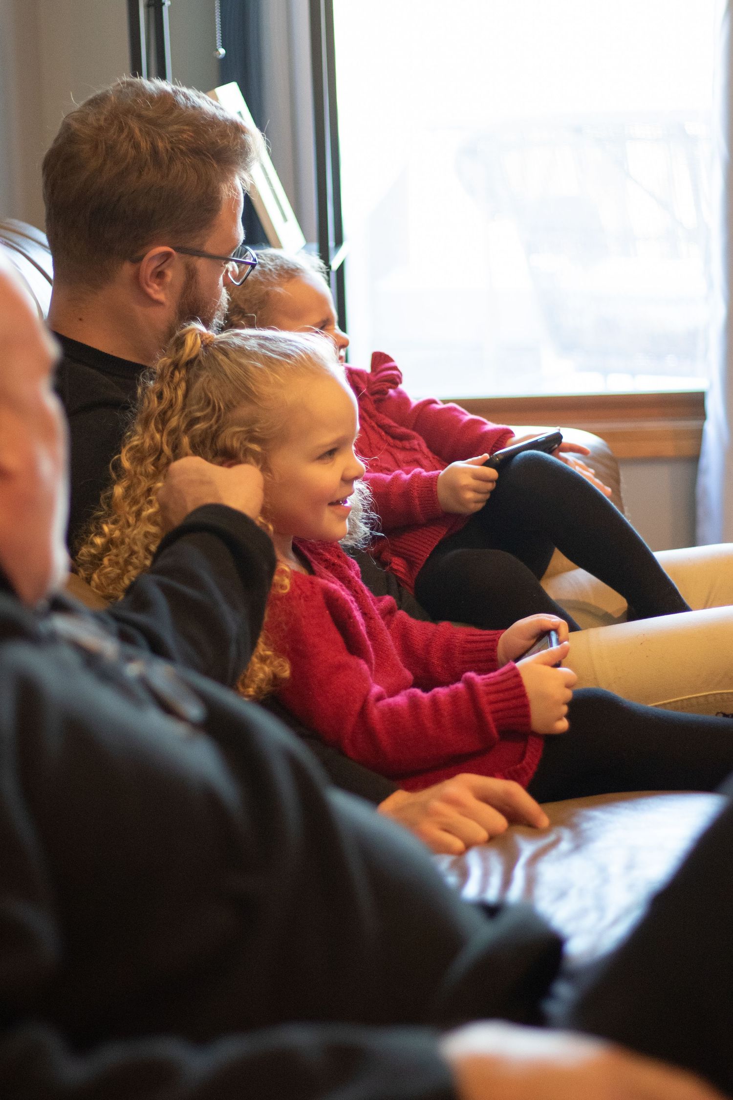 Bride's nieces happily watch wedding ceremony with grandfather and dad sitting beside them