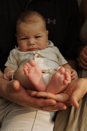 Close-up photo of tiny baby feet being held in adult hands.