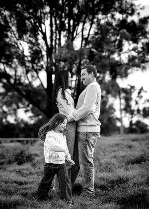 Black and white romantic couple photoshoot showing candid moments together in a natural outdoor setting with trees.