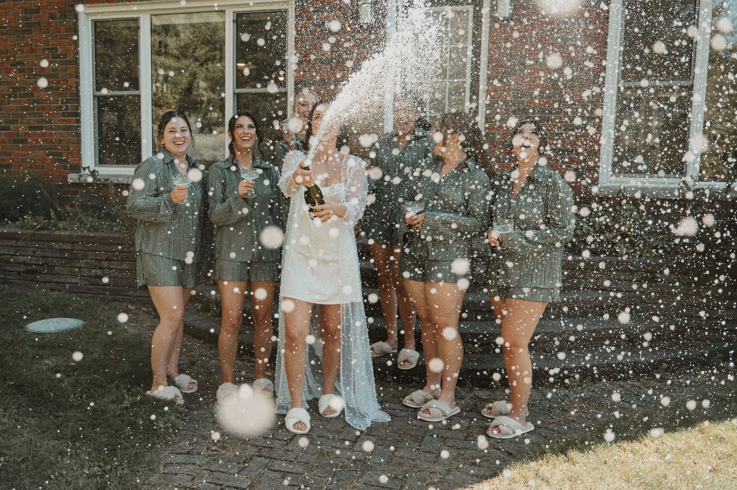 Party guests dance joyfully together in a rustic wooden barn venue with festive decorations.