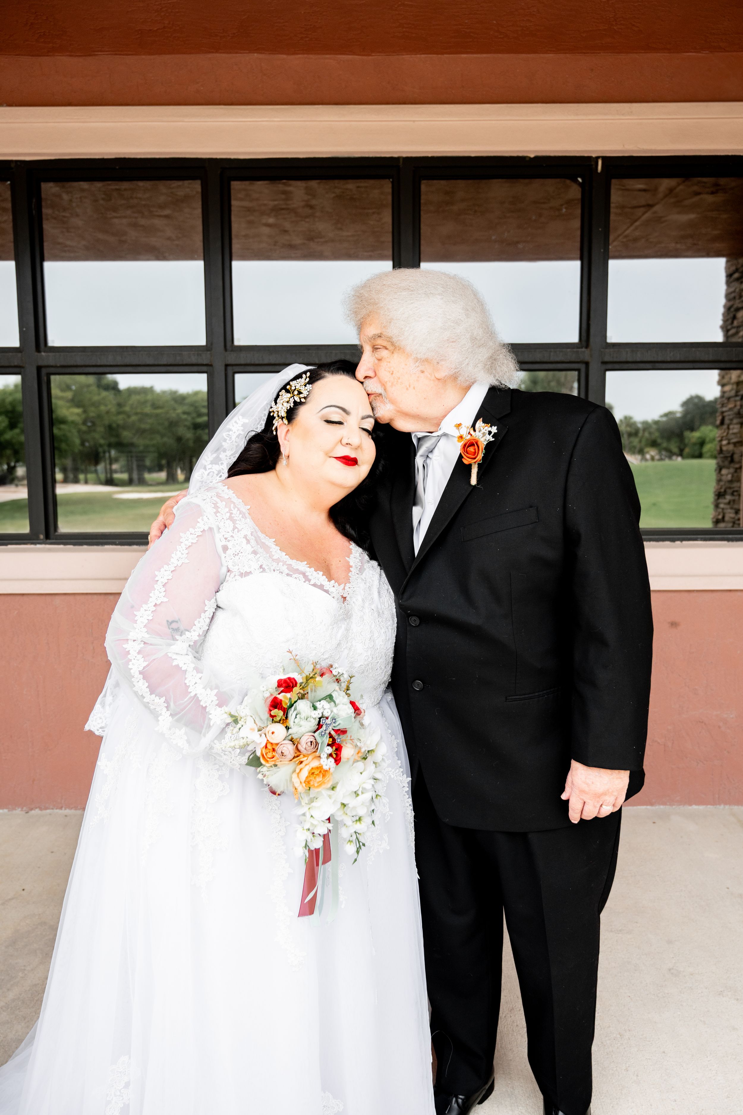 Wedding couple sharing a moment in front of a modern building.