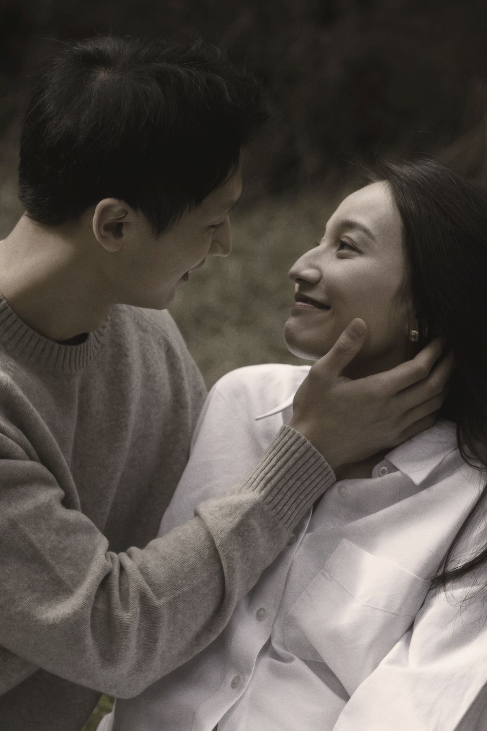 A romantic couple sharing tender moments in moody black and white photography.