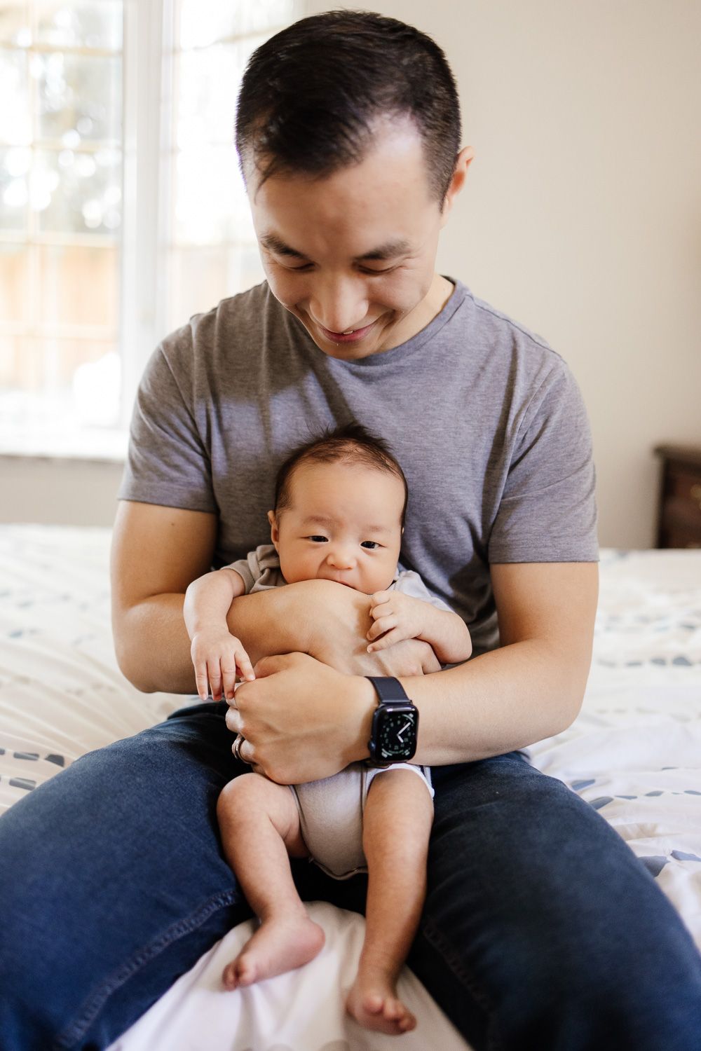 A dad holds his newborn baby - in-home family session Bay Area