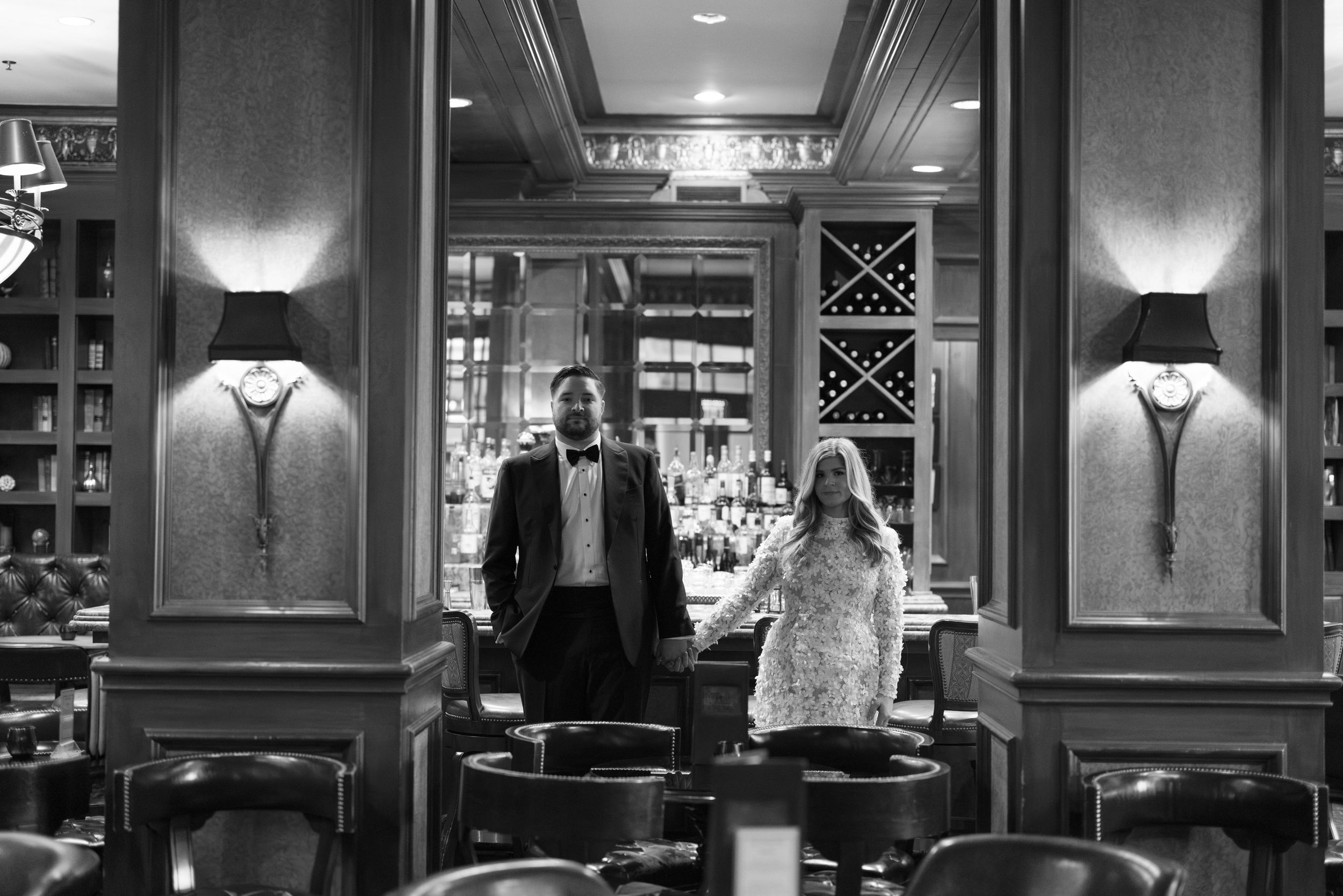A dimly lit restaurant interior with elegant dining tables, wall sconces, and classic decor creating an intimate atmosphere.