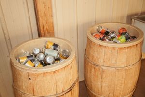 Two wooden barrel coolers filled with assorted canned beverages on ice.