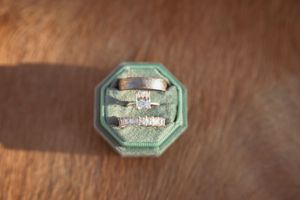 Antique mint green octagonal ring box with velvet interior on wooden surface.