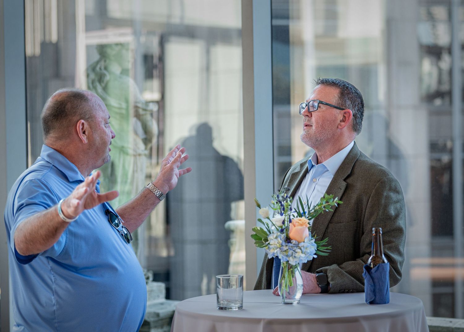 Business professionals engage in animated conversation at networking event.