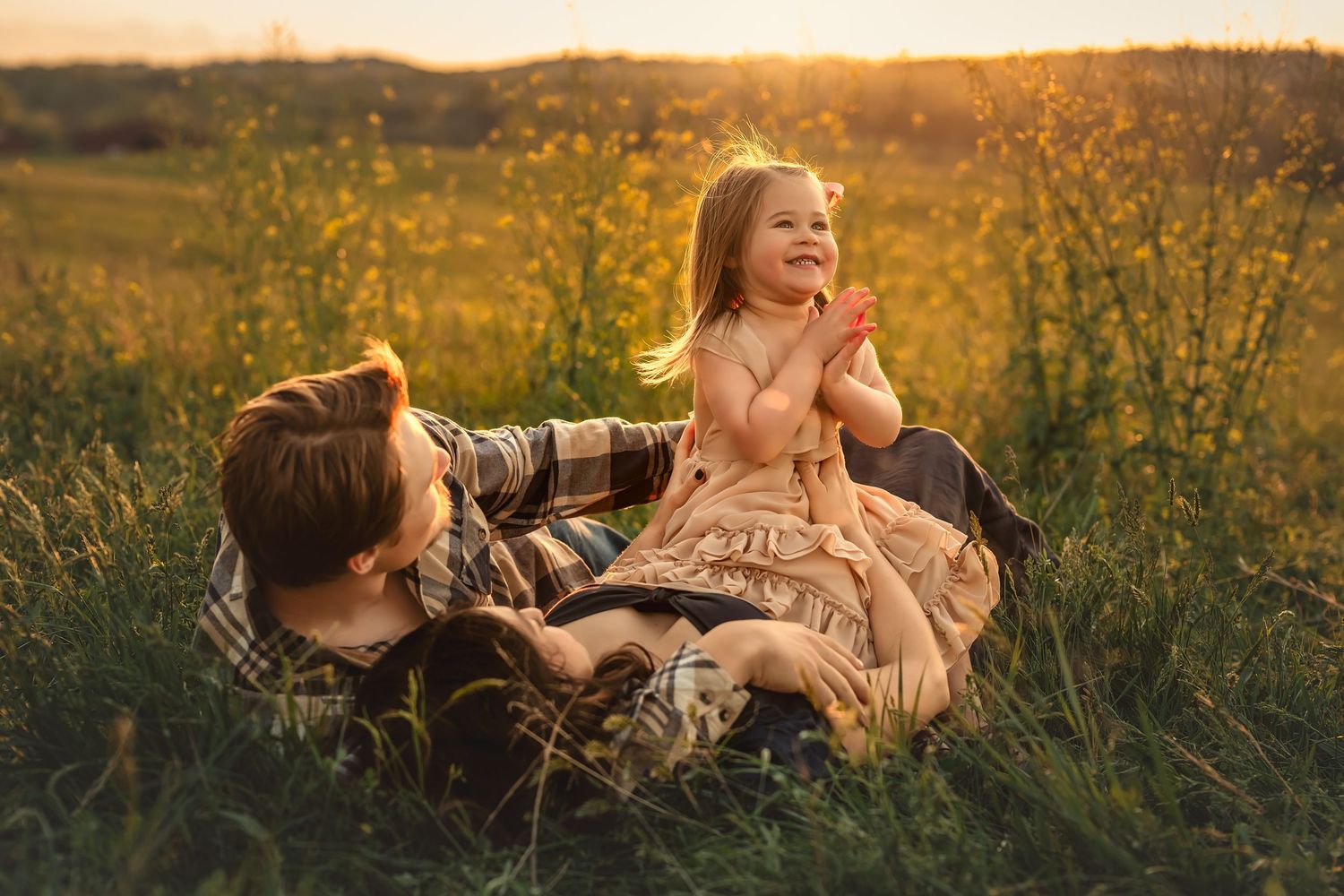 A romantic golden hour photoshoot in a wildflower meadow as the sun sets on the horizon.