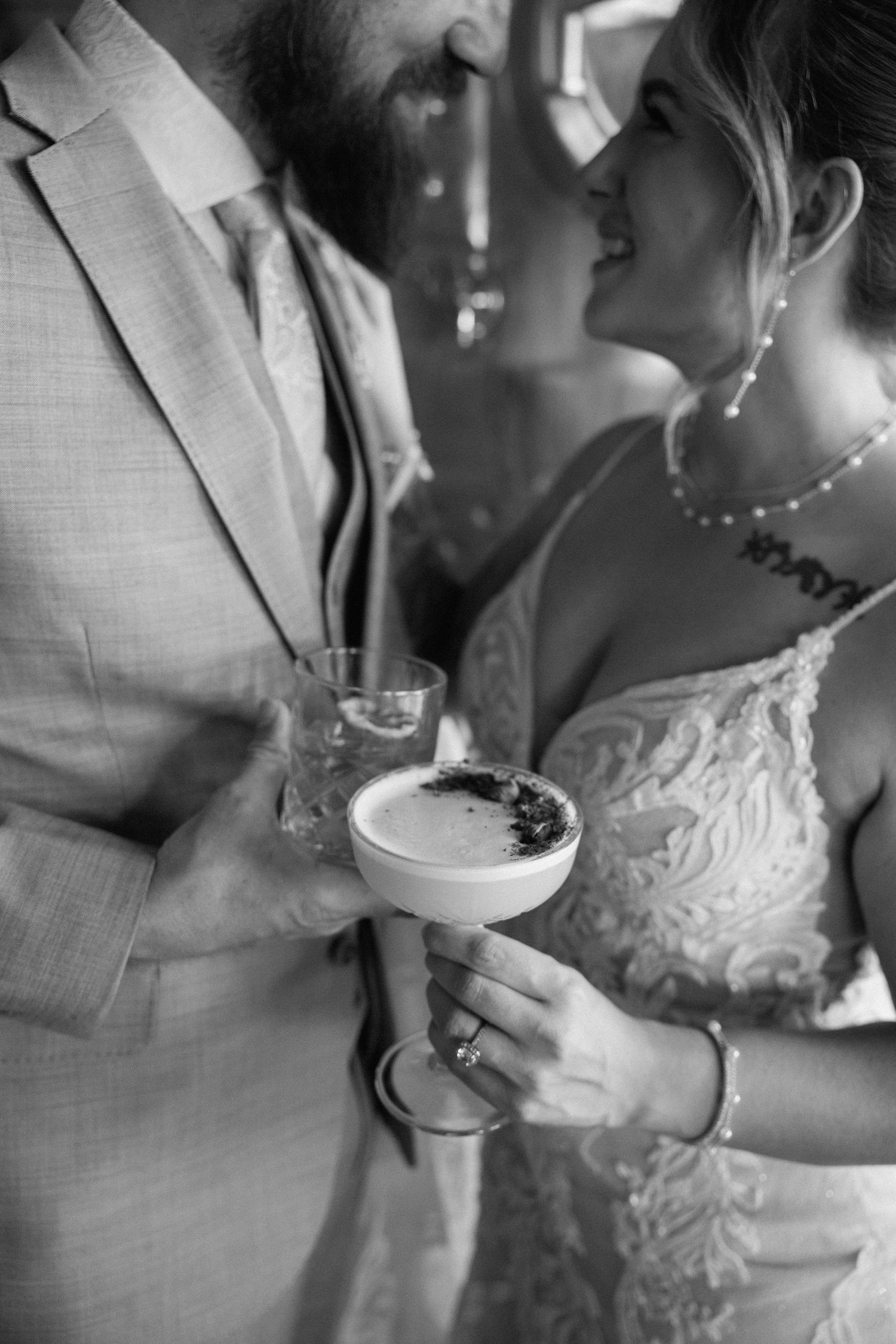 Close-up black and white shots of a couple sharing dessert at their wedding reception.