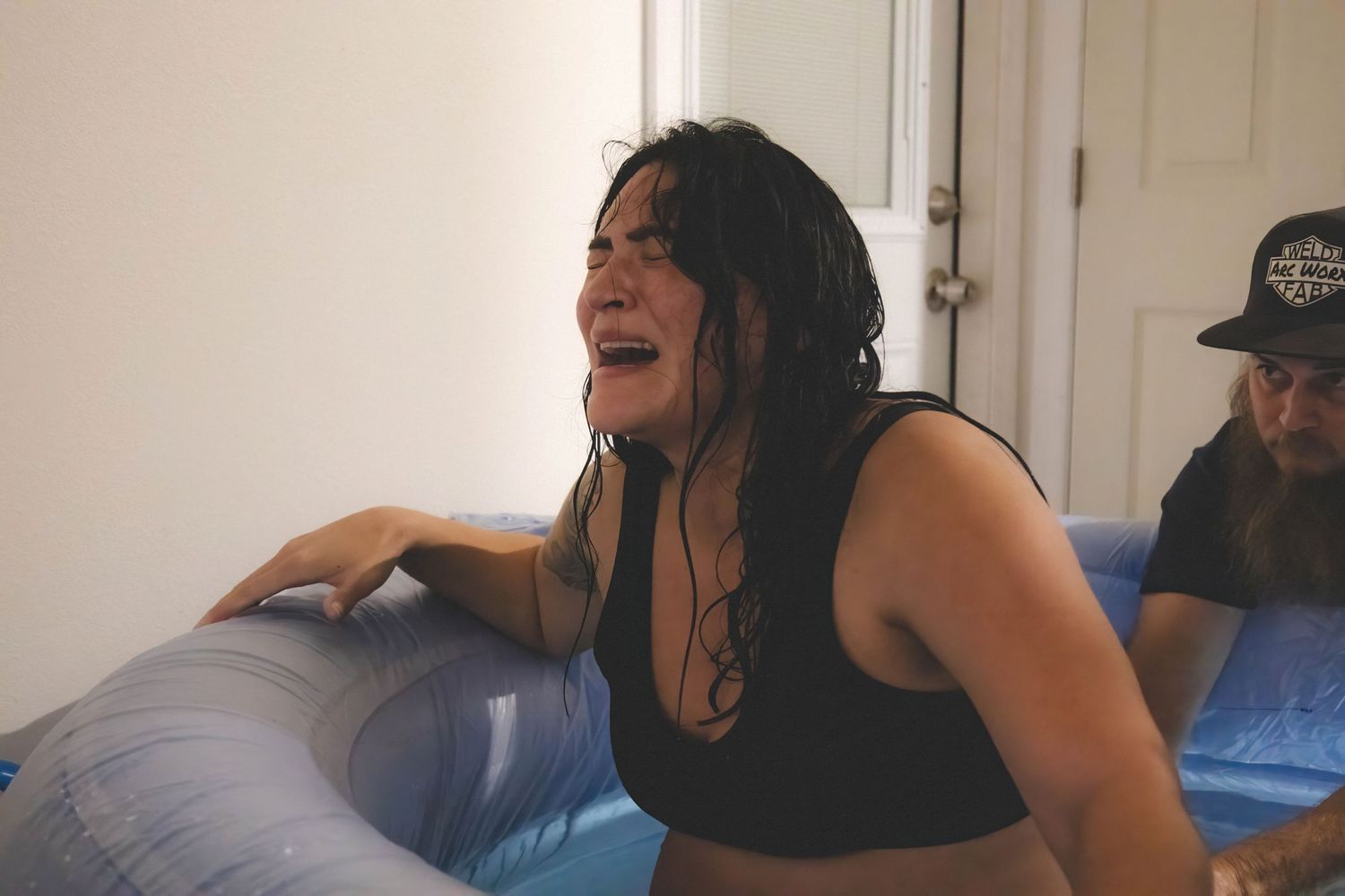 A person laughs heartily while sitting on a couch in a series of four sequential photos.