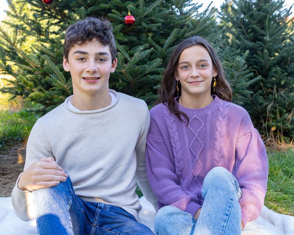 Siblings pose together at Mistletoe Christmas Tree Farm in Stow, MA at holiday photos by Lisa West Photography www.lisawestphotography.com