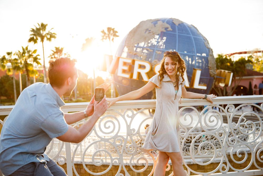 A special moment unfolds at sunset in front of the Universal Studios globe, with palm trees and golden light in the background.