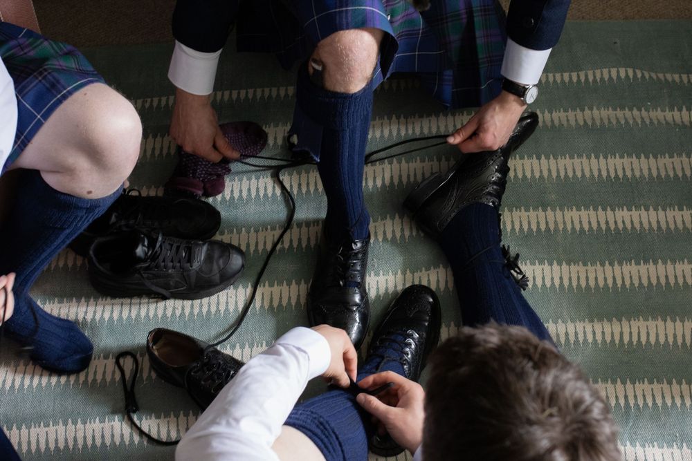 Close-up view of shoes and feet on a textured floor.