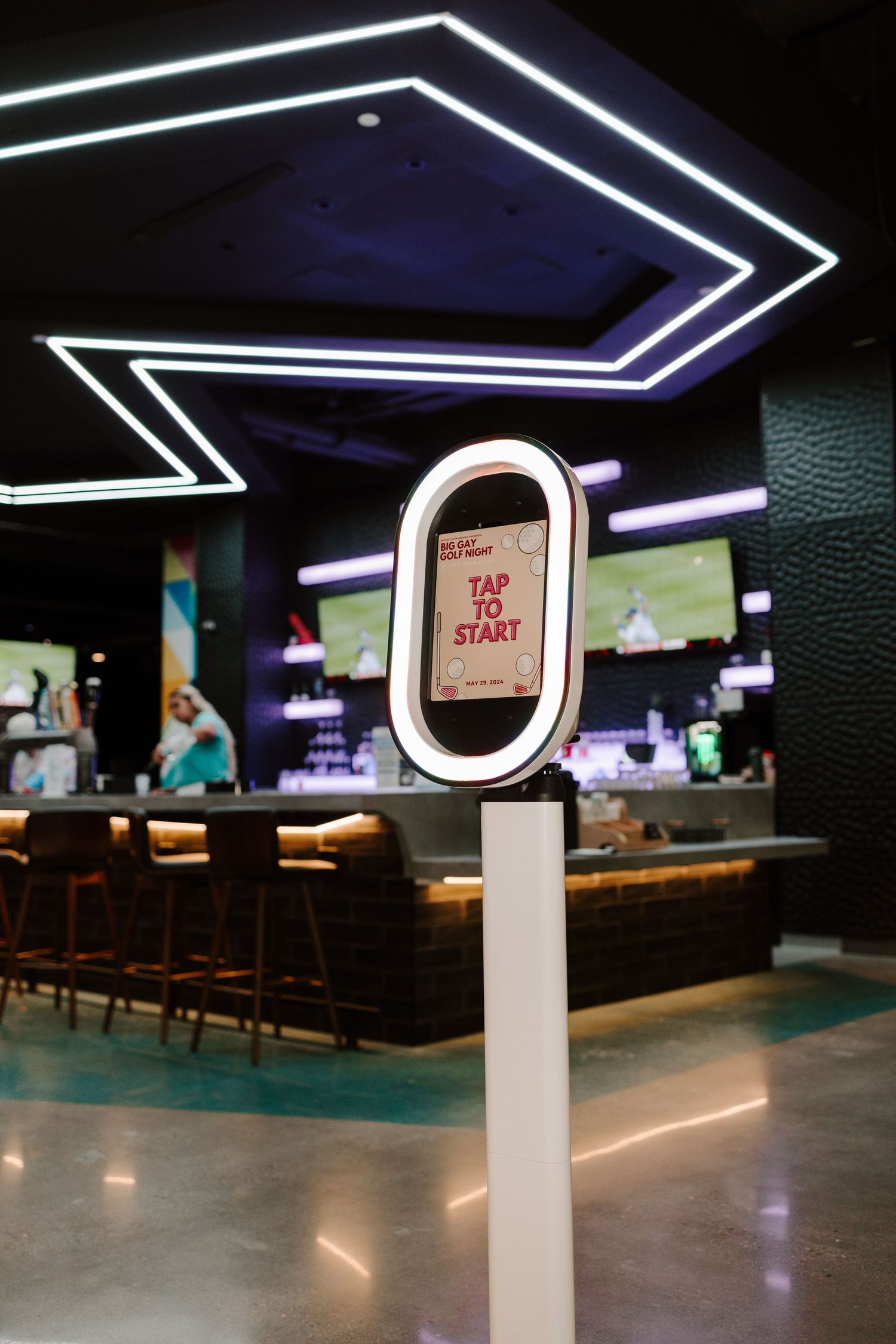 Modern restaurant ordering kiosk with geometric LED lighting on ceiling.