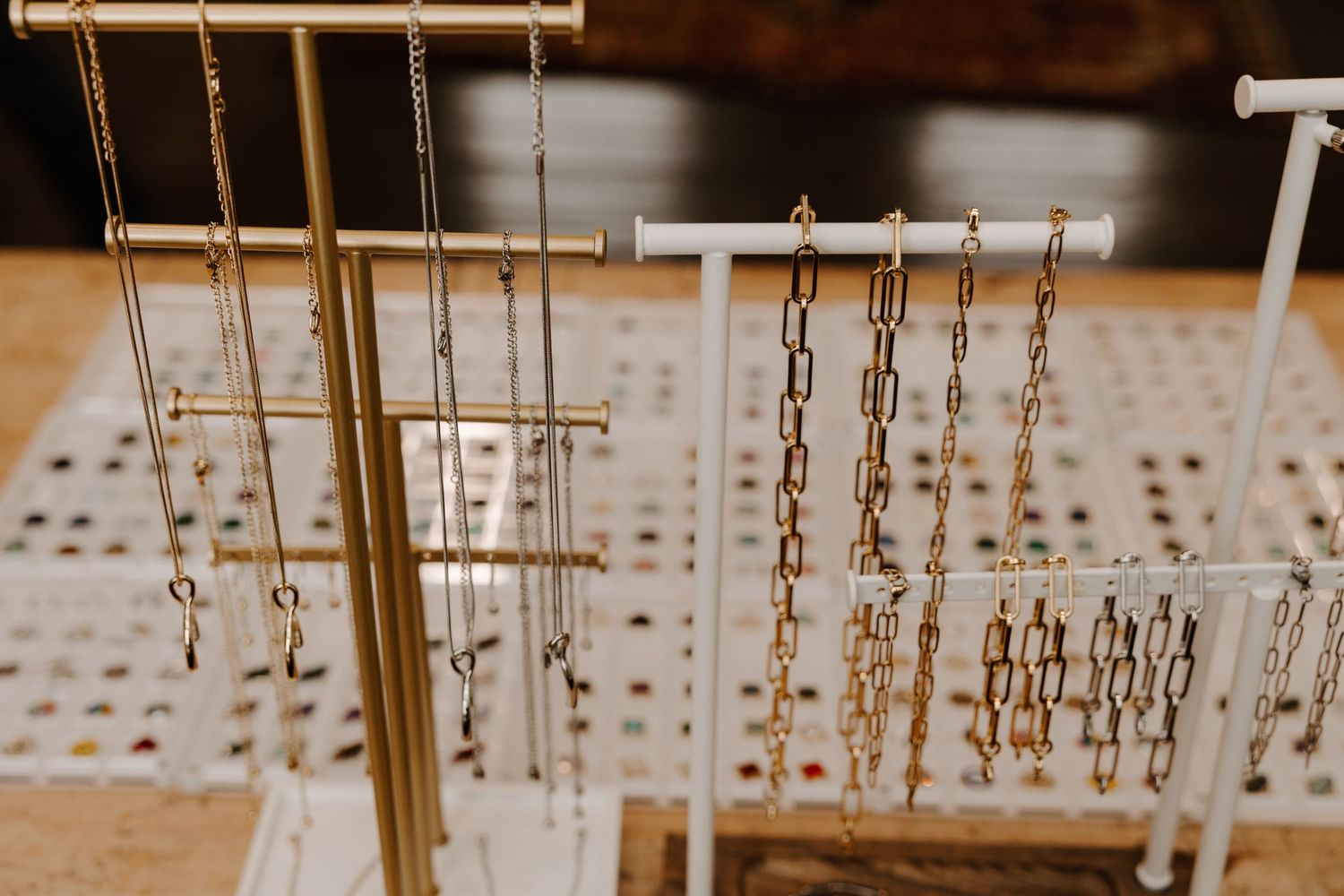Close up of jewelry display stands with hanging gold necklaces and chains.