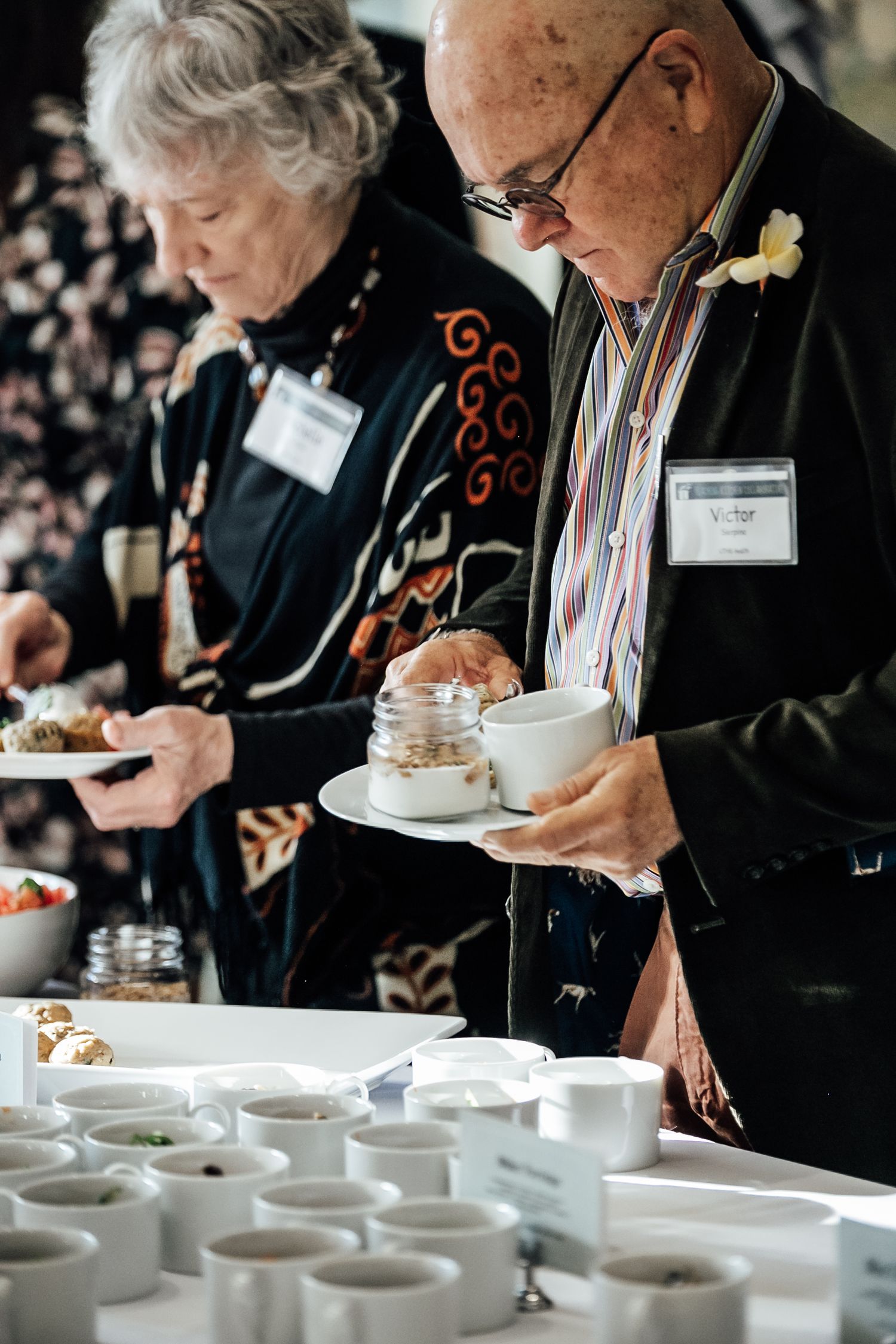 Elderly couple serving themselves at an elegant coffee and tea service station.