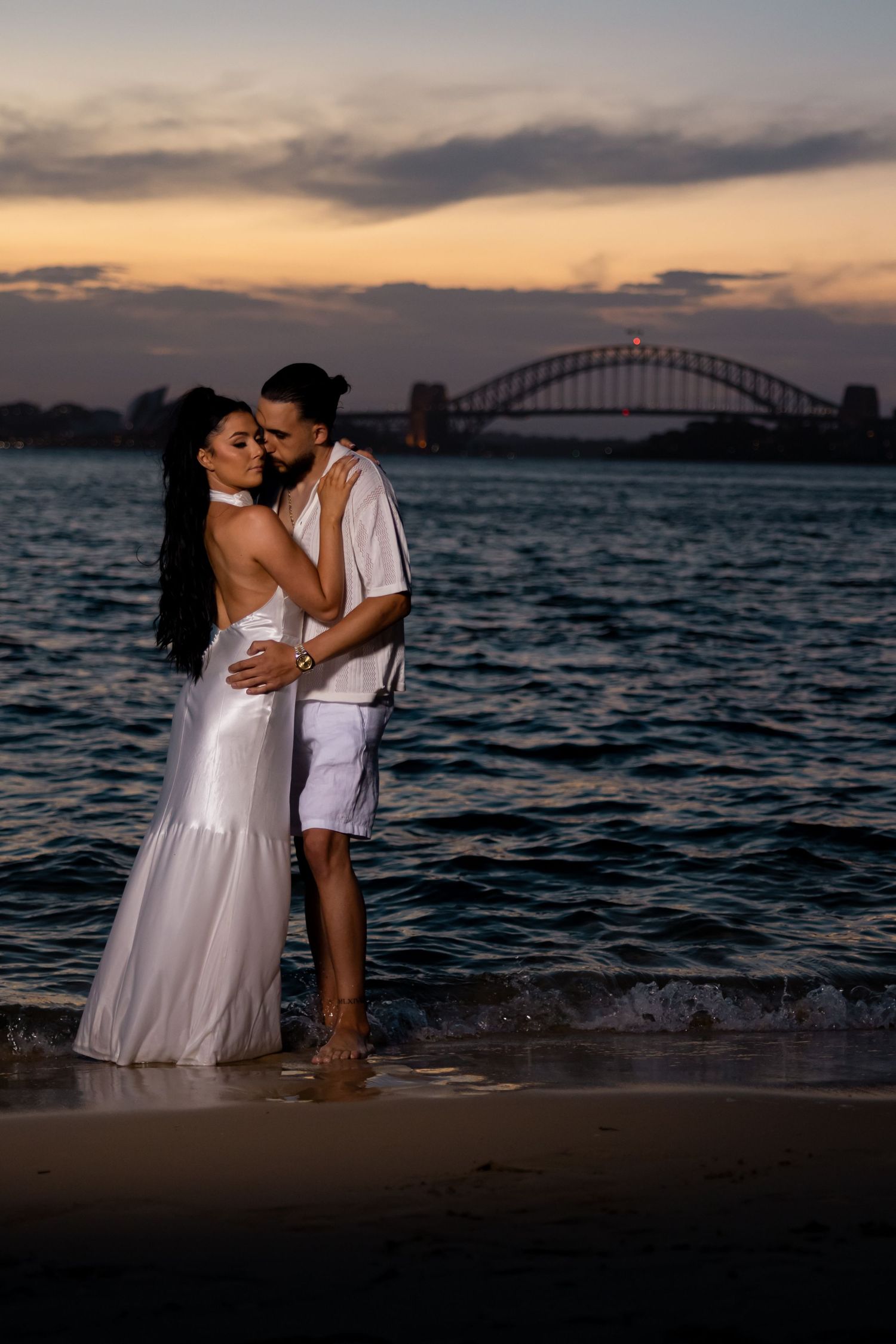 Romantic sunset moment at Sydney Harbour with iconic bridge in the background.
