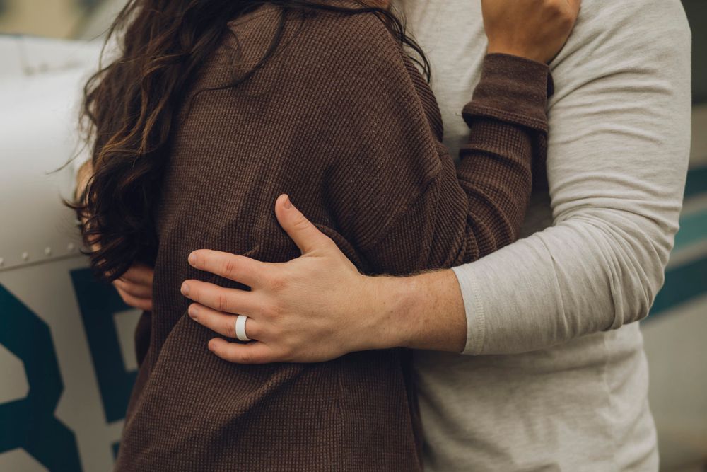 Detail shot of a couple with hands wrapped around each other.