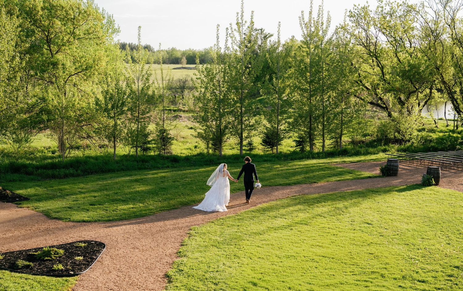 Wedding couple and attendants pose for formal portraits on landscaped grounds of elegant venue.