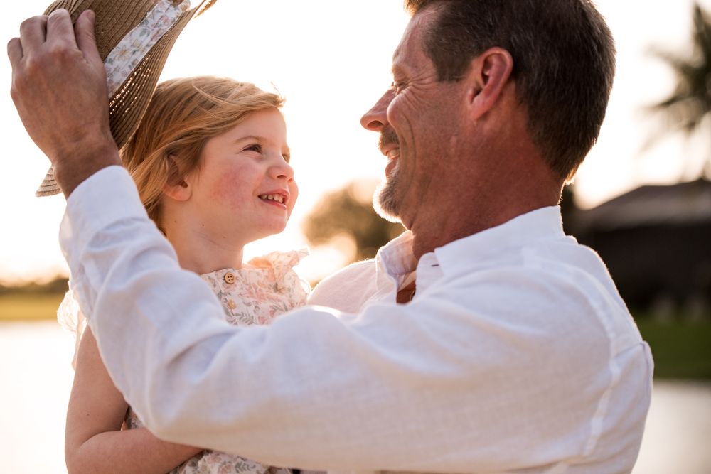 Heartwarming moment captured during sunset between two people in white attire.