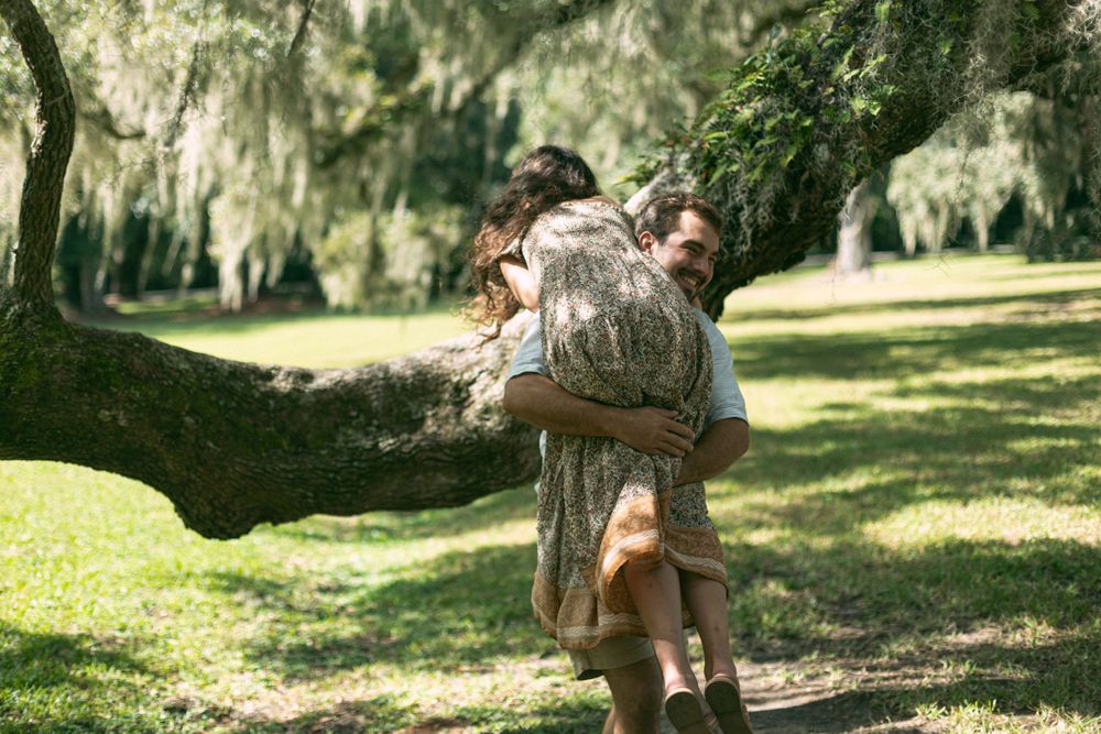 A playful moment captured on a large tree branch in a Southern garden setting.